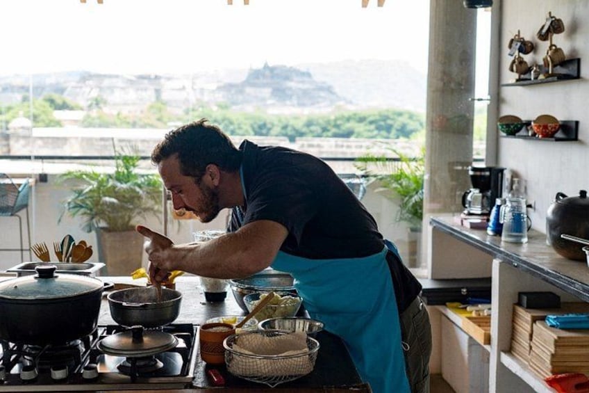 Una persona cocinando en una cocina con vista a la ciudad. 5