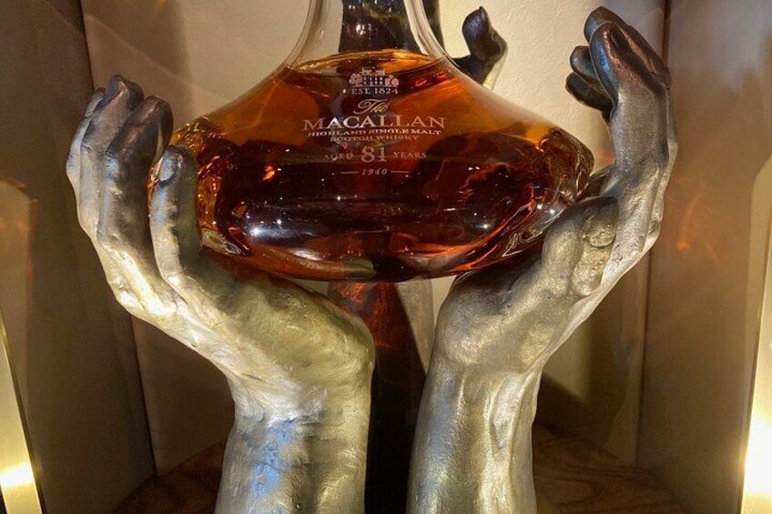 A sculpture of hands holding a bottle of Macallan whisky. 4