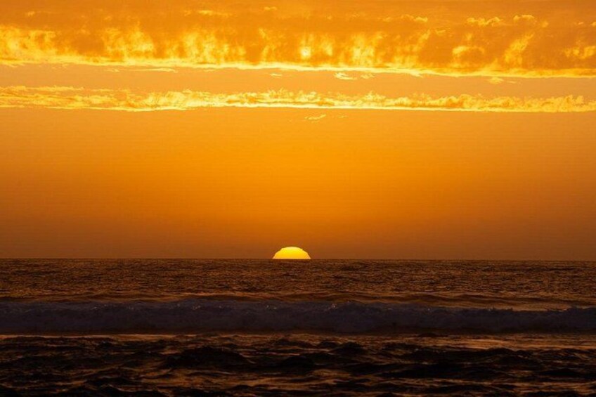 A sunset over the ocean with waves and a clear sky. 3