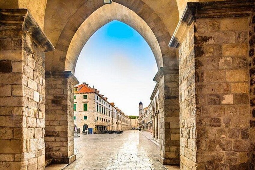 An arched stone bridge with buildings in the background. 3