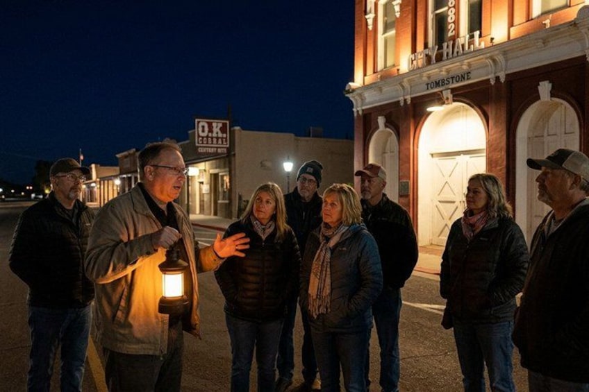 Un groupe de personnes se tient devant un bâtiment sur lequel on peut lire l’inscription « Hôtel de ville ». 1