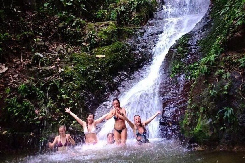 A waterfall with people enjoying the water. 4