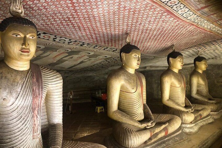 De grandes statues de Bouddha sont assises dans un temple dont le plafond et les murs sont ornés de motifs. 2