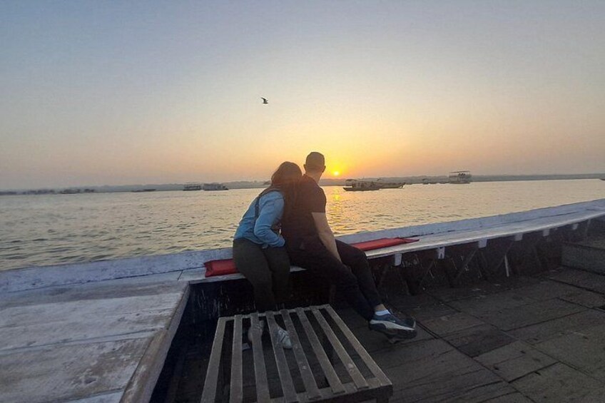 Dos personas sentadas en un banco junto a la orilla durante el atardecer. 4