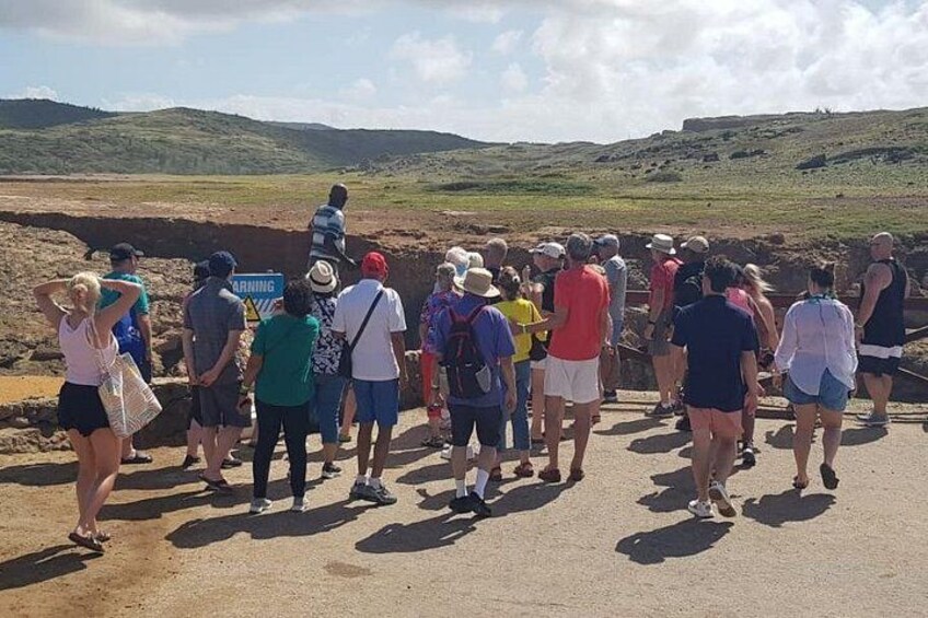 A group of people walking on a dirt path in a hilly landscape. 3