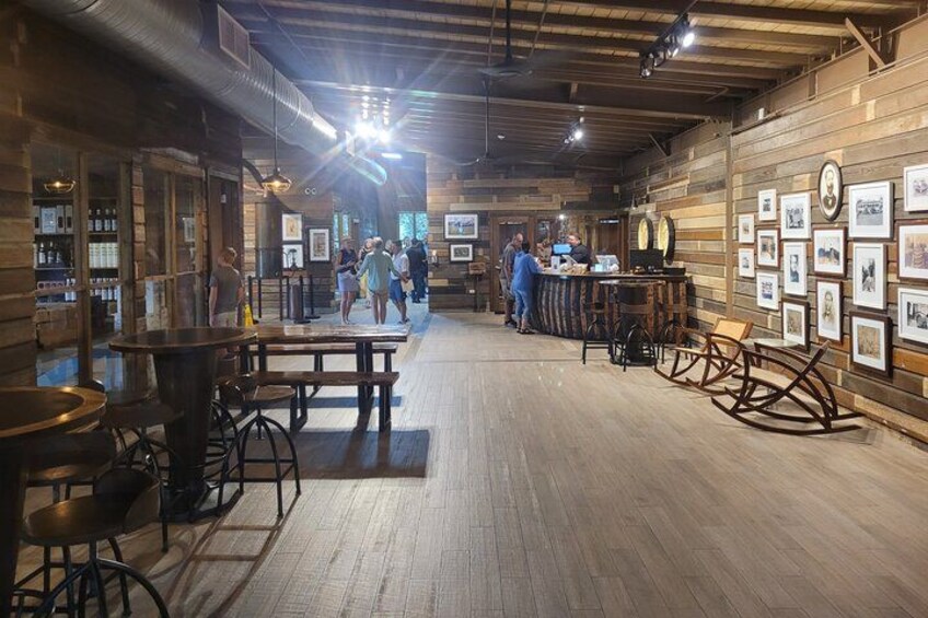 A rustic interior with wooden walls, a bar area, and framed pictures on the walls. 2