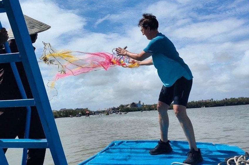 A person on a blue platform by a body of water, holding a colorful kite. 3