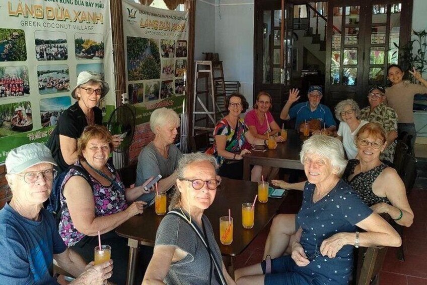 Een groep mensen zit aan een tafel in een restaurant, met een menukaart op de achtergrond. 5