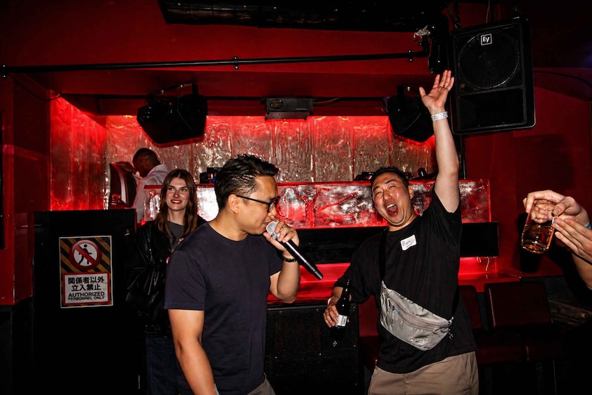 A person holding a microphone, another person raising their hand, and a sign with a prohibition symbol. 2