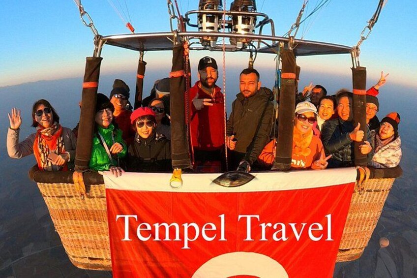 A group of people on a cable car with a banner reading 'Tempel Travel'. 1