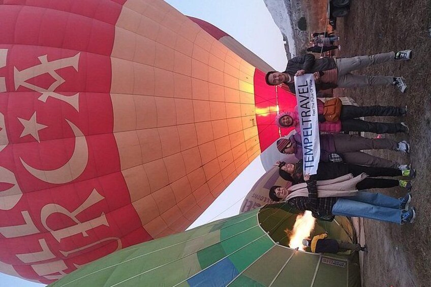 A hot air balloon with a group of people standing underneath it. 2