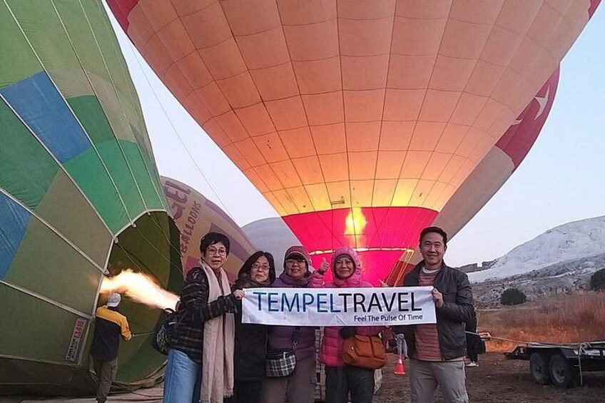 A group of people holding a banner in front of a hot air balloon. 5