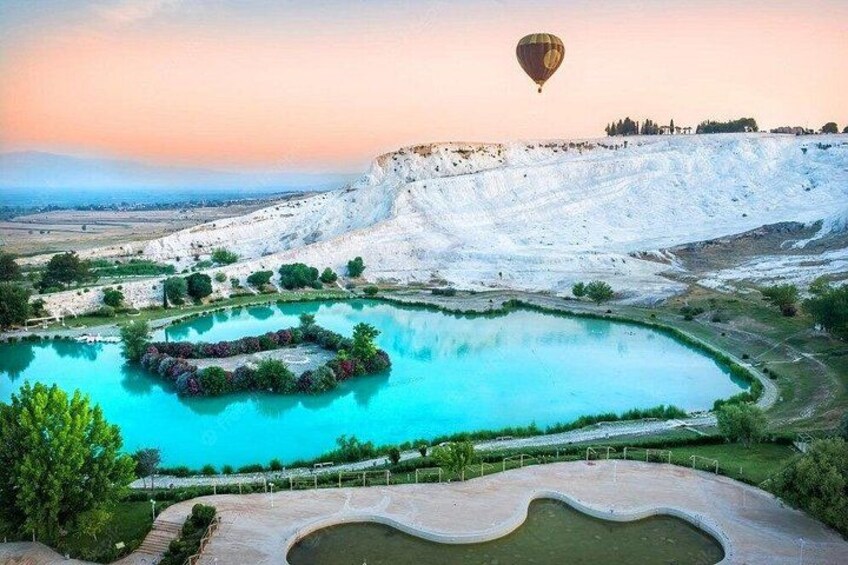 A hot air balloon, a large turquoise lake, and a white cliff. 3
