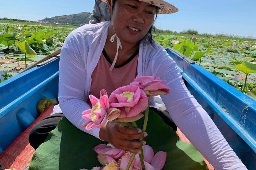 A person in a boat holding lotus flowers. 3