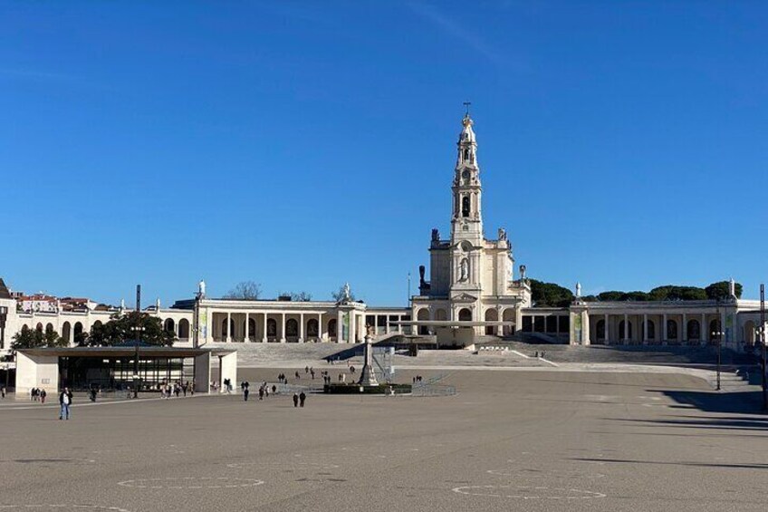 A large open plaza with a prominent church featuring a tall bell tower. 1