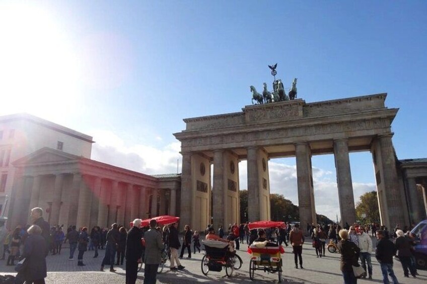 The Brandenburg Gate, a historic monument surrounded by a busy public square with people and a horse-drawn carriage. 5