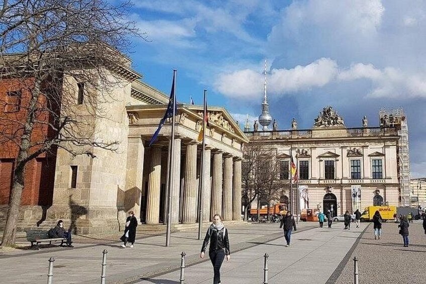 A historic building with columns, flags, and a statue. 2