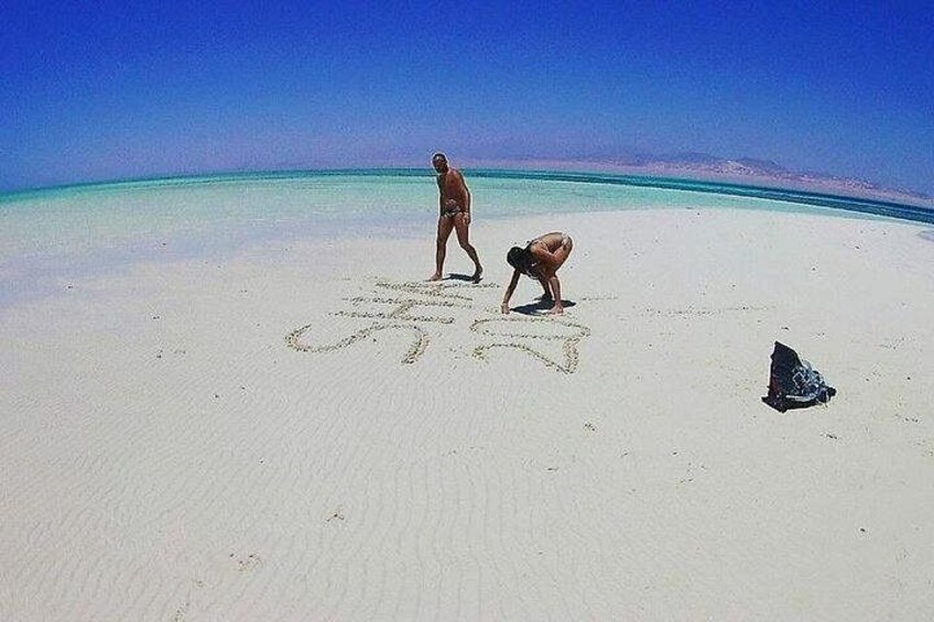 A beach with footprints and a towel on the sand. 4
