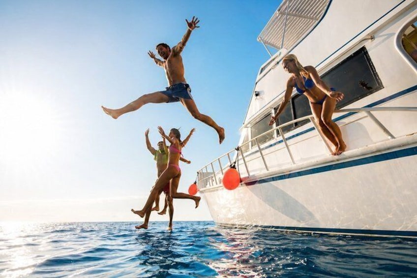 People jumping into the ocean from a boat. 1