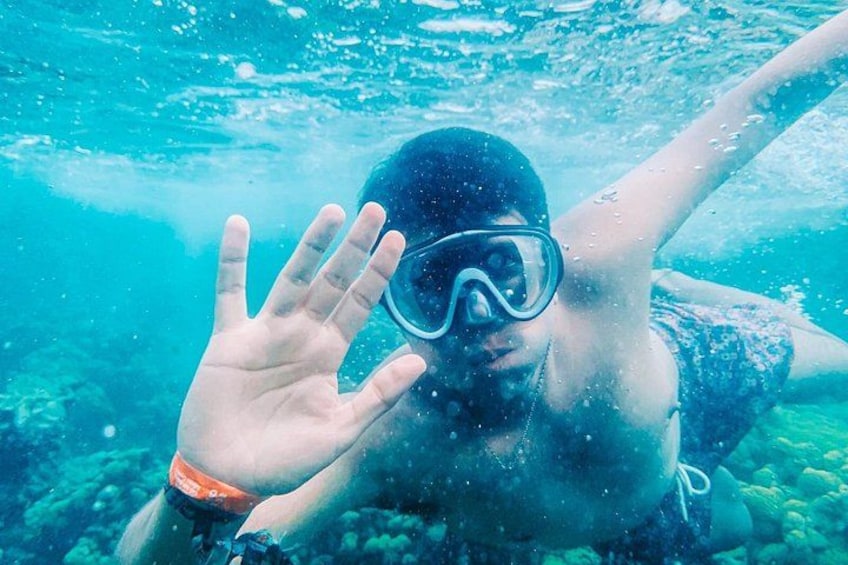 A person snorkeling underwater with a hand extended forward. 1