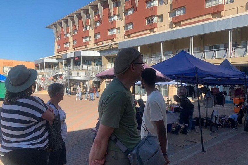 A market with people and tents in an outdoor setting. 2