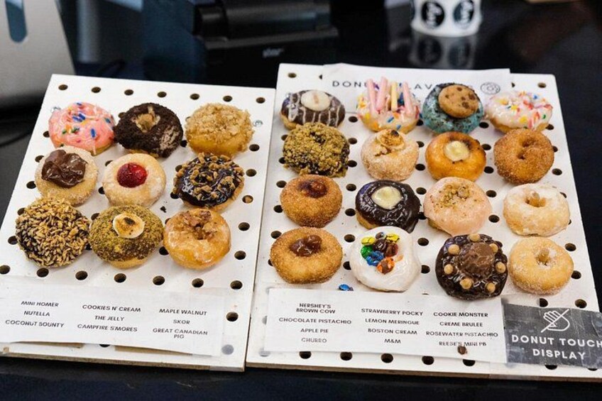 Two trays of assorted donuts with various toppings and flavors. 4