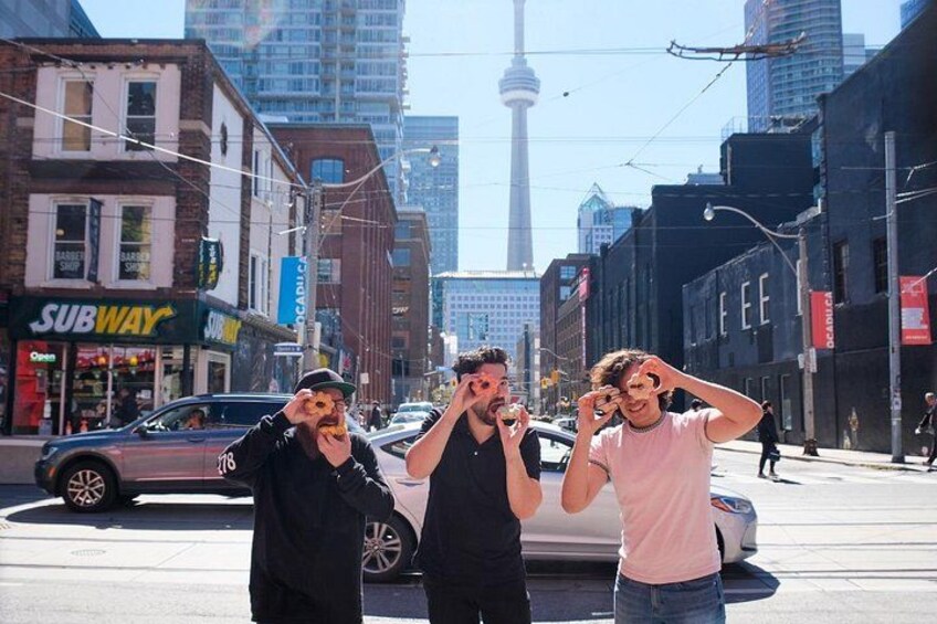 Three people posing on a city street with a view of a tower in the background. 5