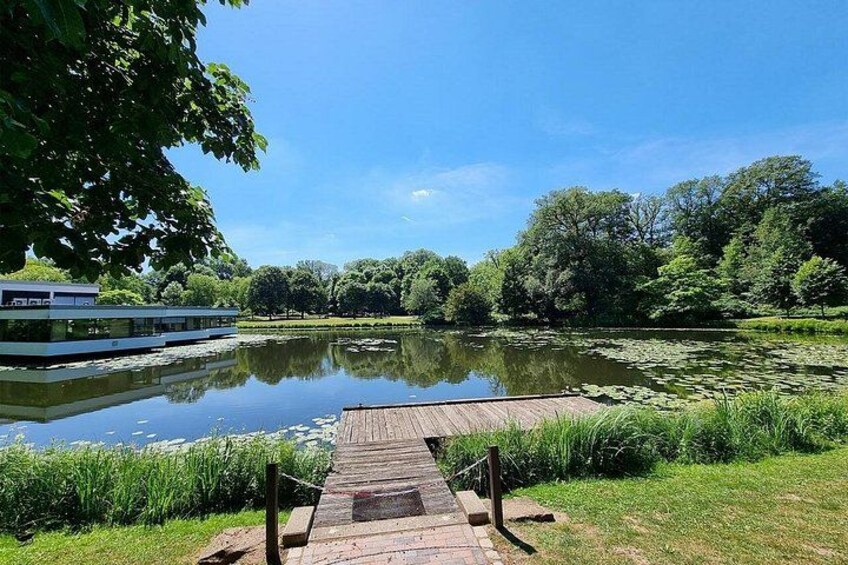 A wooden dock extending into a calm lake surrounded by lush greenery and trees. 2
