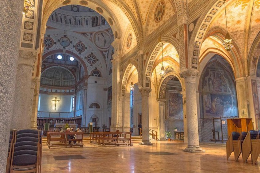An interior of a grand cathedral with high vaulted ceilings, large stained glass windows, and ornate stone columns. 4