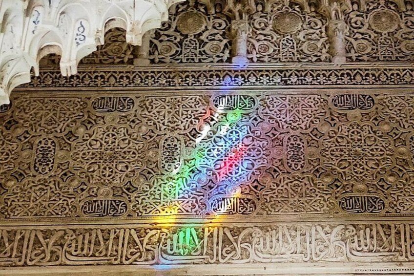 An intricately carved wall with Arabic calligraphy and geometric patterns. 2