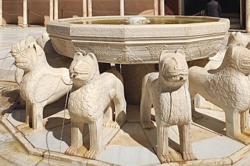 A marble fountain with lion statues. 1