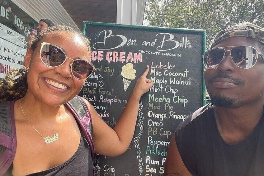 A person pointing at a menu board listing ice cream flavors. 2