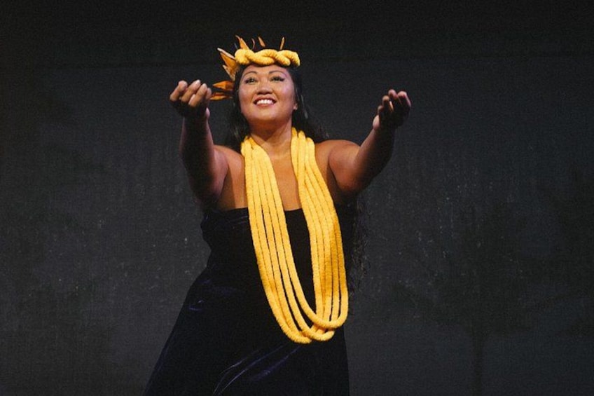 A person in a dark dress with a yellow scarf and a headpiece. 3