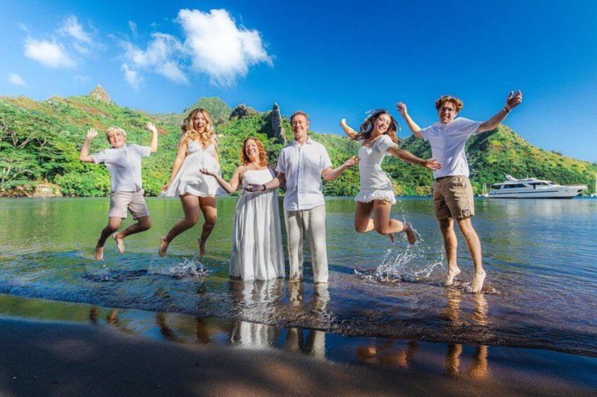 A group of people jumping into a body of water with a boat in the background. 5