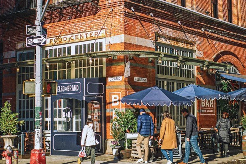A brick building with a food center sign, a bar, and outdoor seating with umbrellas. 5