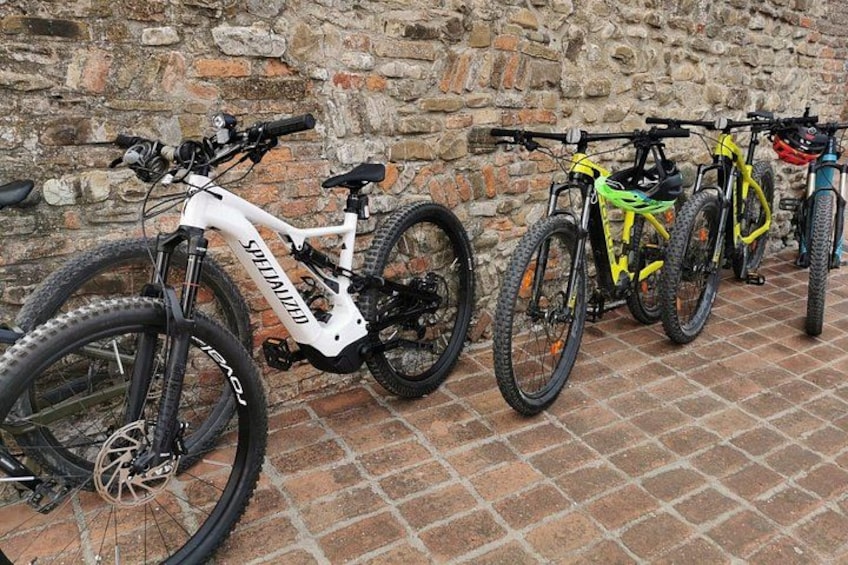 Una fila de bicicletas de montaña al pie de un muro de ladrillo. 1