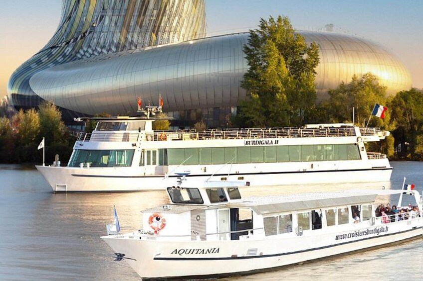 Dos barcos, uno llamado AQUITANA y el otro BURDGALA II, atracados cerca de un edificio moderno con fachada curva. 2