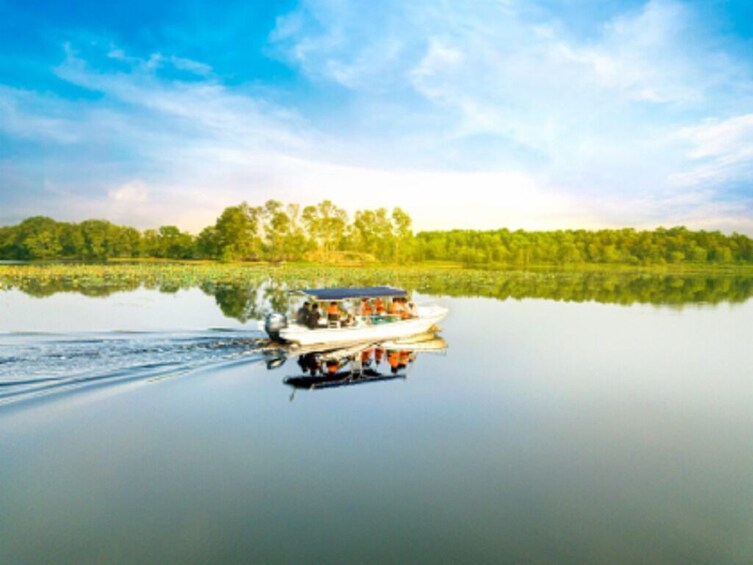 Een boot op een kalm meer, met een bos op de achtergrond. 4