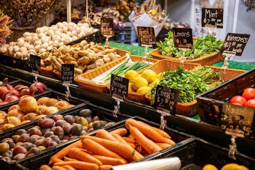 Un mercato con diverse verdure in mostra, come carote, patate e cipolle. 3