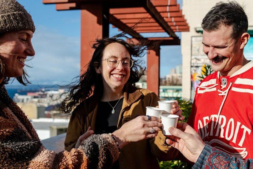 Three people holding cups, a red sports jersey, and a building in the background. 1