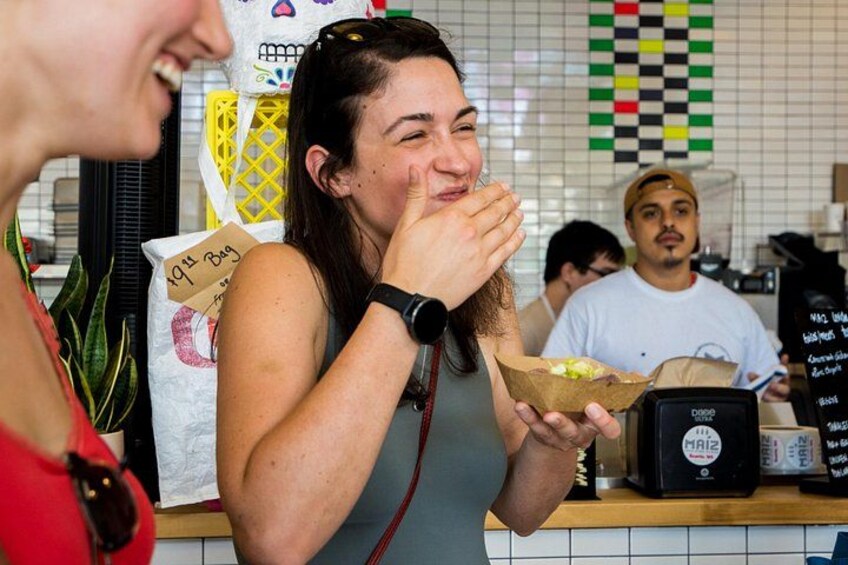 Una persona tiene un sacchetto di carta con cibo, una bilancia digitale e un pannello con il menu in un caffè. 5