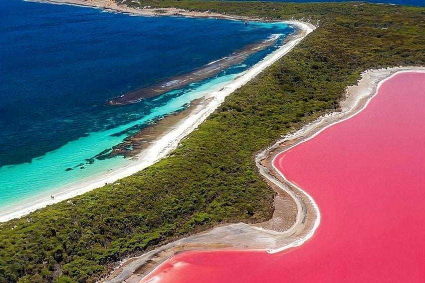 An aerial view of a coastal area with a beach, a red water body, and a turquoise sea. 4
