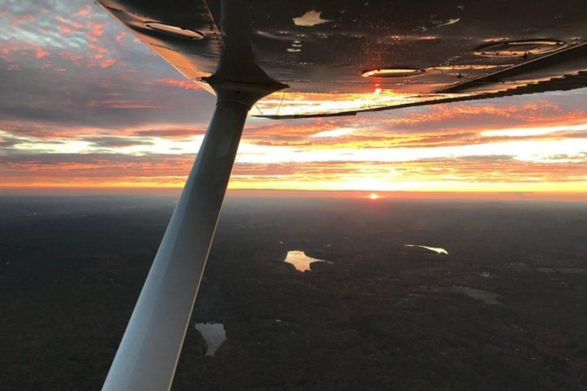 A sunset with a plane's wing in the foreground. 2