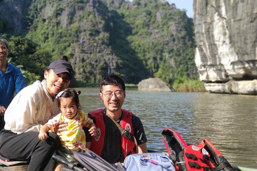 A group of people on a boat near a river with cliffs in the background. 5