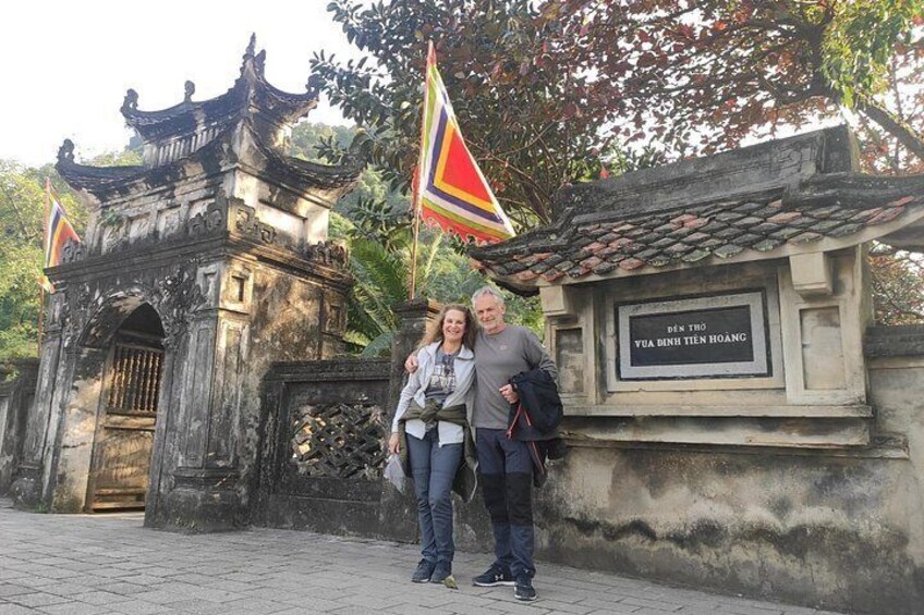 A historical gate with inscriptions, a traditional roofed structure, and flags. 5