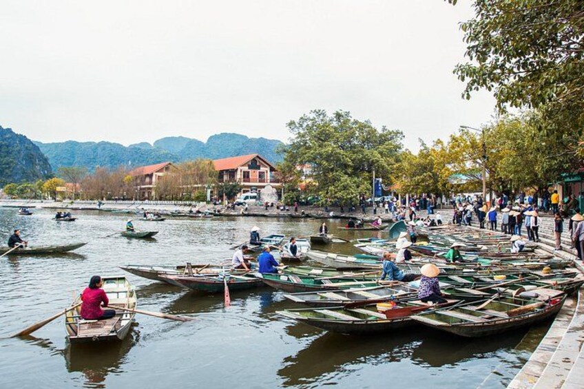 A river with boats, people, and buildings along the shore. 3