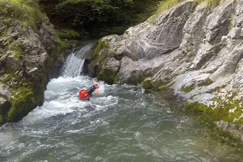 A person kayaking through a narrow, rocky waterway surrounded by steep cliffs. 2