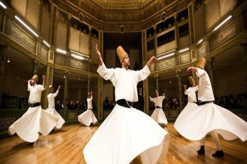 Un grupo interpreta un baile tradicional en un salón amplio con arquitectura ricamente decorada. 2
