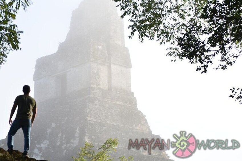 A person standing in front of a large, ancient stone structure. 2