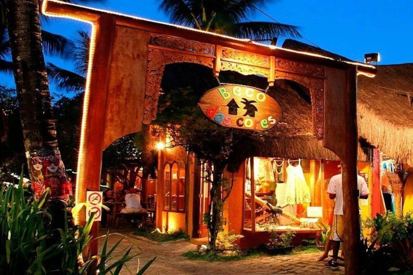 A thatched-roof structure with a sign reading 'Beco de Coco,' surrounded by tropical vegetation. 1
